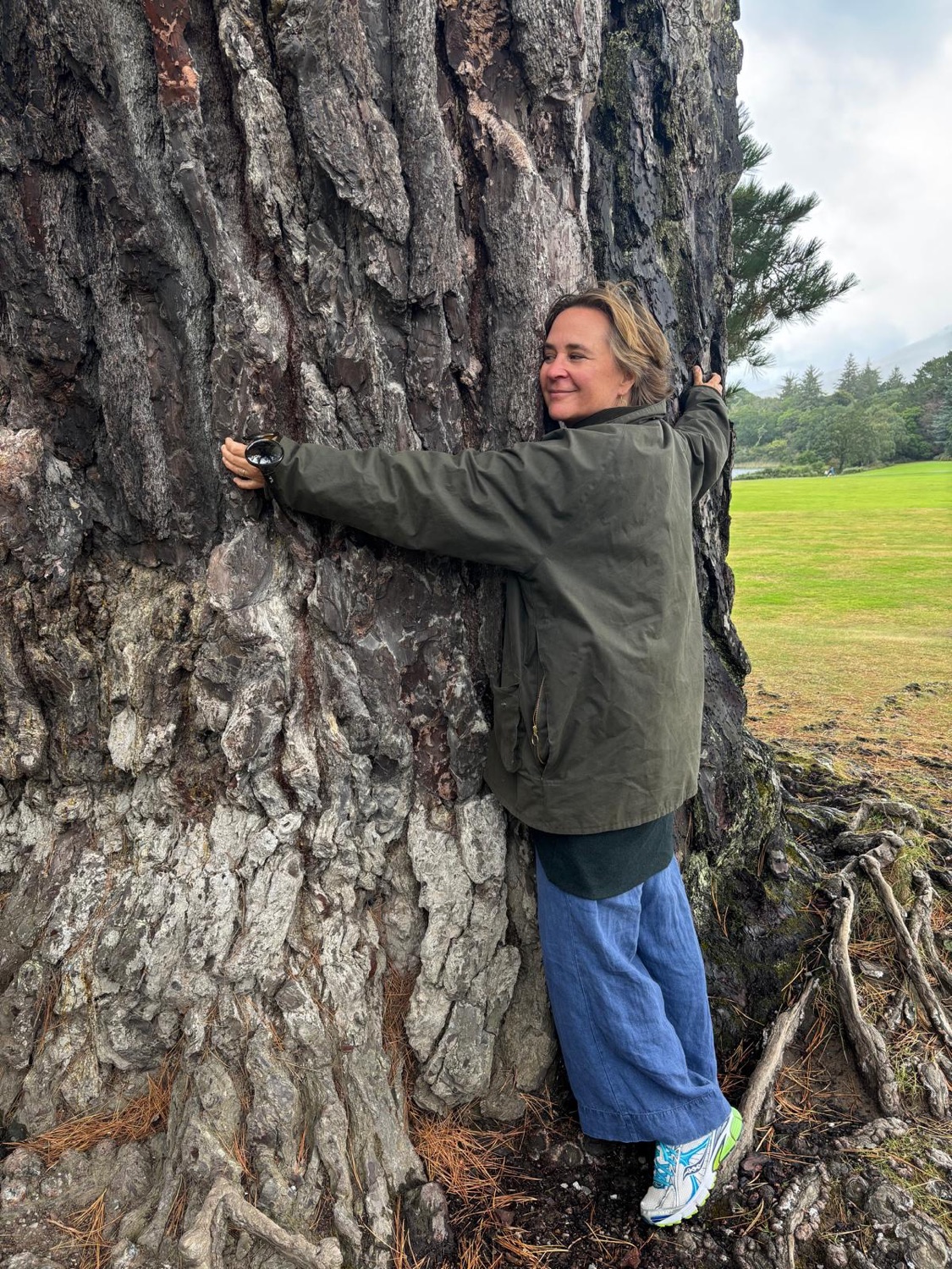 Mia Ladányi umarmt einen großen alten Baum